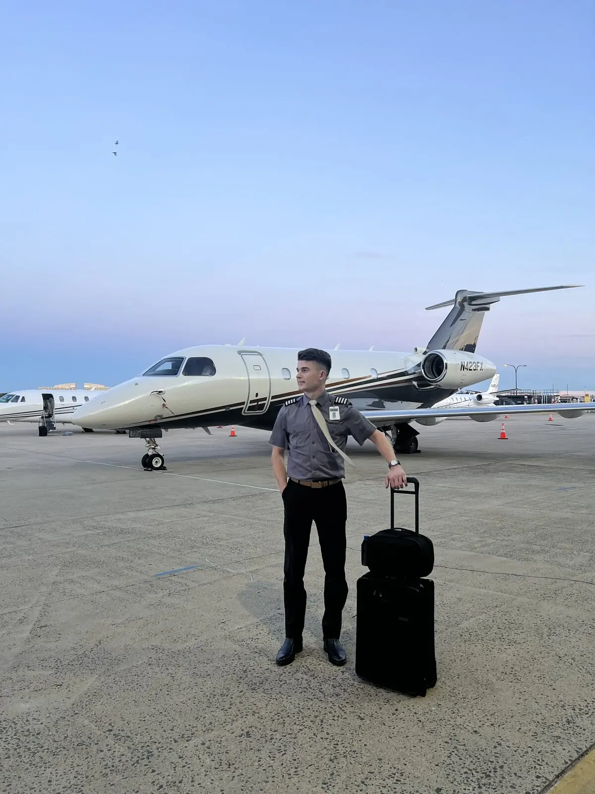 Gheorghe Ciobanu in uniform beside a Praetor 500/600 jet at dusk